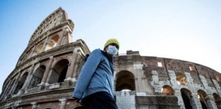 Un hombre camina delante del Coliseo de Roma durante la pandemia por coronavirus.