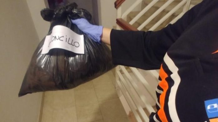 Una voluntaria de Protección Civil entrega material en un domicilio.