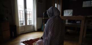 Una joven musulmana se dispone para el rezo en su dimicilio, durante el confinamiento por el coronavirus.