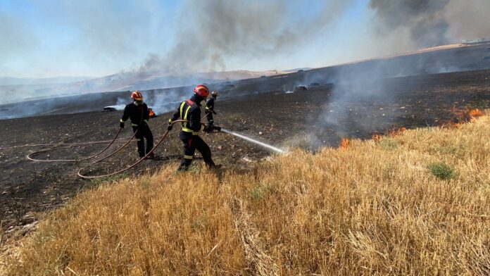 Extinguiendo el incendio que se propagó por El Casar desde Valdepiélagos.