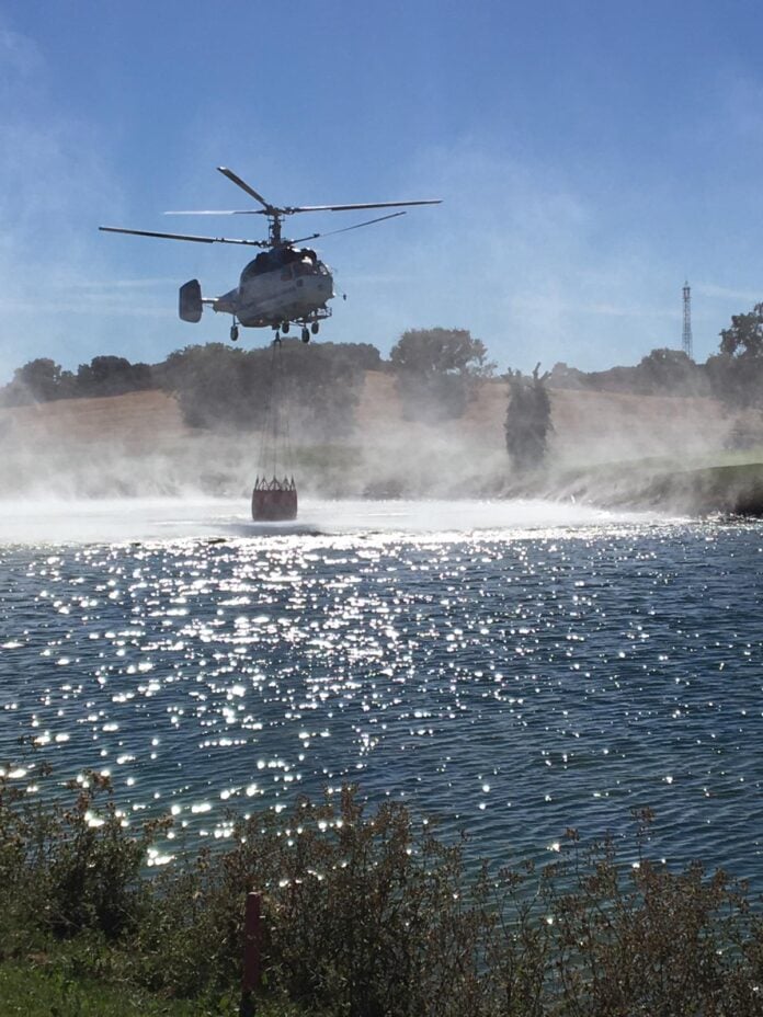 Baldeando con un helicóptero contra incendios desde un estanque del campo de golf de Valdeluz.