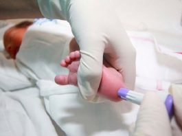 Realización de la prueba del talón a un recién nacido.