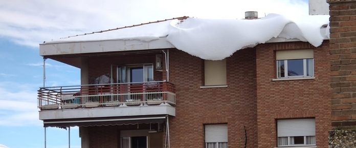 Gran cantidad de nieve a punto de caer desde un tejado de un edificio de Guadalajara.