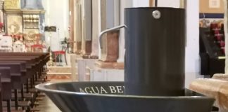 Dispensador de agua bendita en una iglesia.