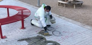 Operario limpiando una de las pintadas en un parque del barrio de Manantiales, en mayo de 2021.