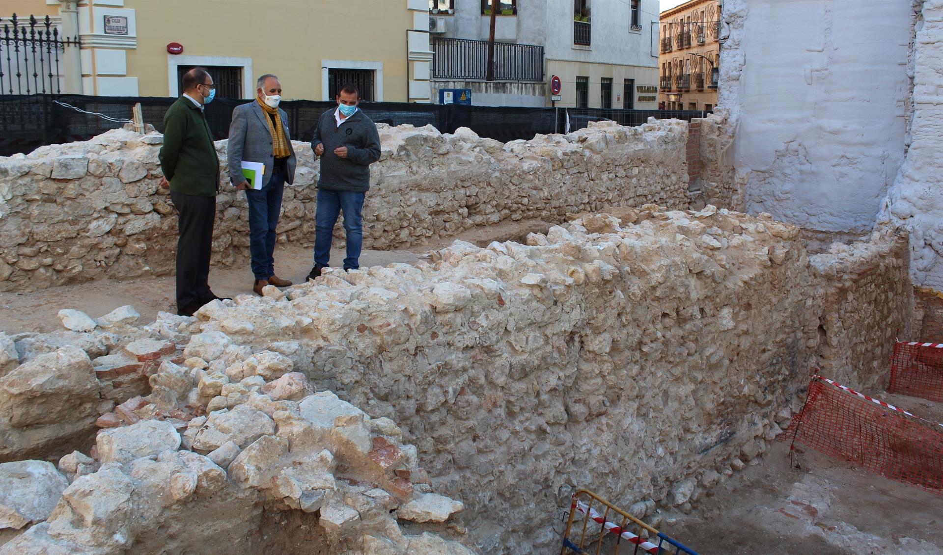 El delegado de Cultura y otros responsables, ante los muros aparecidos en el primer nivel de excavación en Santo Domingo.