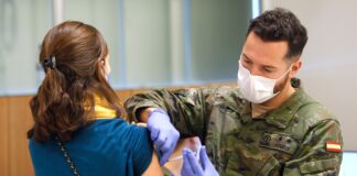 Un militar vacuna a una mujer contra el COVID.