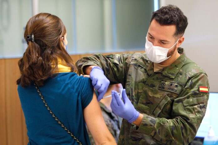Un militar vacuna a una mujer contra el COVID.
