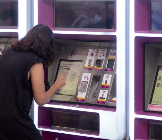 Usuaria de Renfe intentando sacar un billete en una expendedora automática de la estación de Atocha. (Foto: EP)