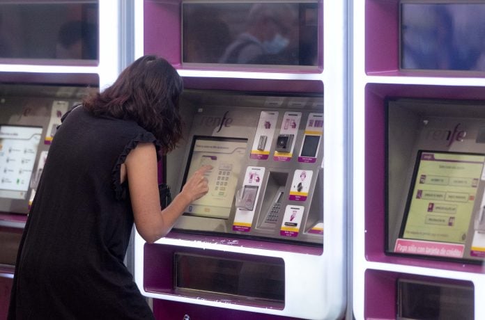 Usuaria de Renfe intentando sacar un billete en una expendedora automática de la estación de Atocha. (Foto: EP)