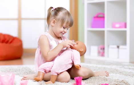 Niña jugando con una muñeca.