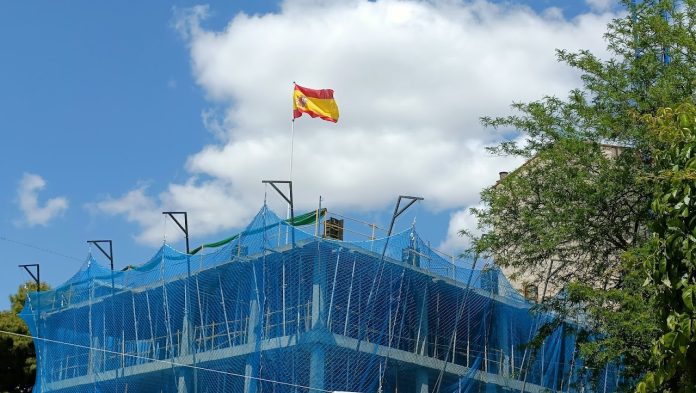 Bandera de España ondeando, a mediados de mayo de 2023, en la obra de un edificio en la Plaza de Santo Domingo, en Guadalajara. (Foto: La Crónic@)