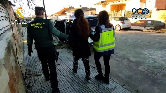 La mujer detenida en esta operación en Torrejón del Rey, camino del coche patrulla.