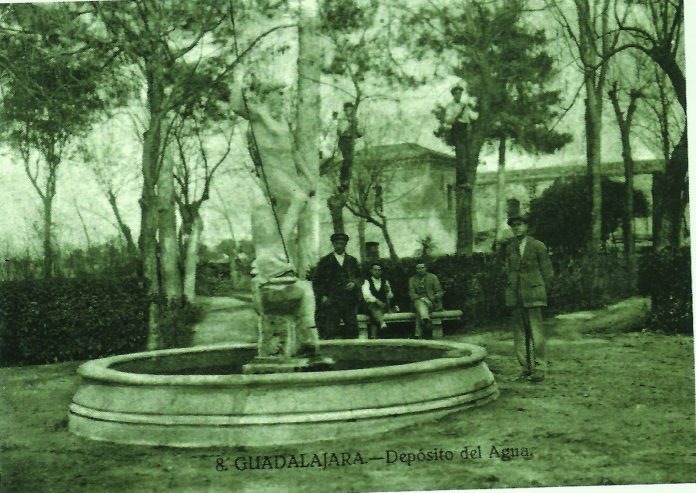 La escultura de Neptuno en los jardines del Depósito de las Aguas, en una portal de hace un siglo.