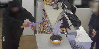 Uno de los detenidos, en pleno atraco de una gasolinera, enarbolando el cuchillo que usaba como "argumento". (Foto: Guardia Civil)