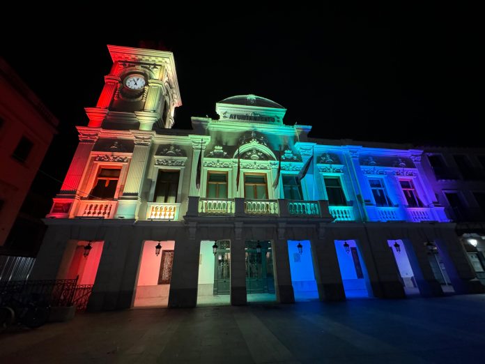La fachada del Ayuntamiento de Guadalajara, iluminada con los colores de la bandera LGTBI el 28 de junio de 2024.