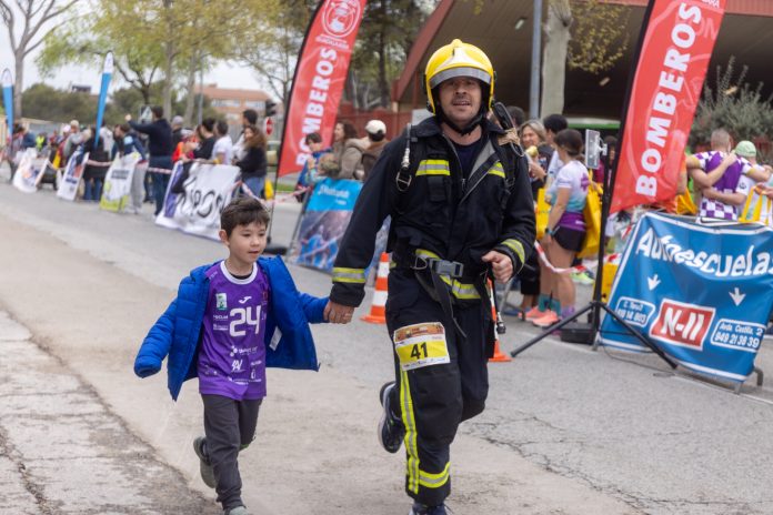 Bombero y niño juntos en una reciente carrera organizada por loa bomberos de Guadalajara.