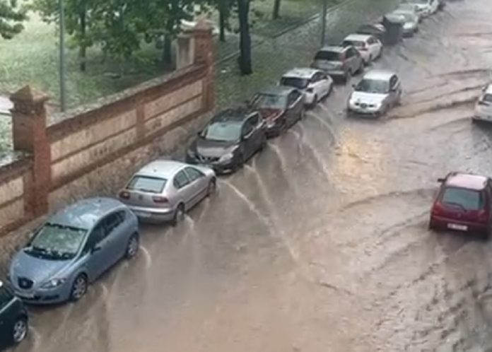 Un torrente de agua bajaba por la calle Ferial este miércoles, mientras el granizo cubría de blanco la ciudad de Guadalajara donde aún no había sido arrastrado por la lluvia.