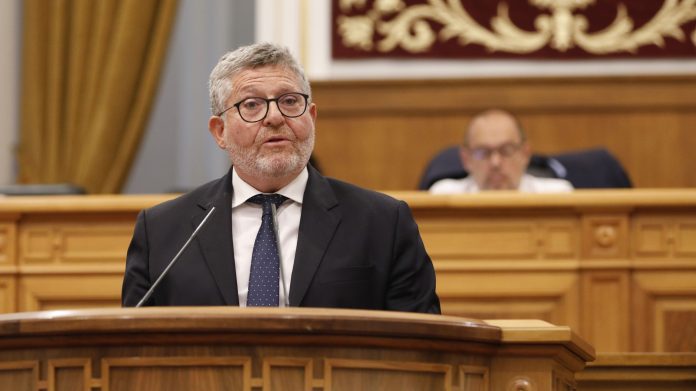 Nacho Redondo durante su intervención este jueves en las Cortes de Castilla-La Mancha. Al fondo, Pablo Bellido.