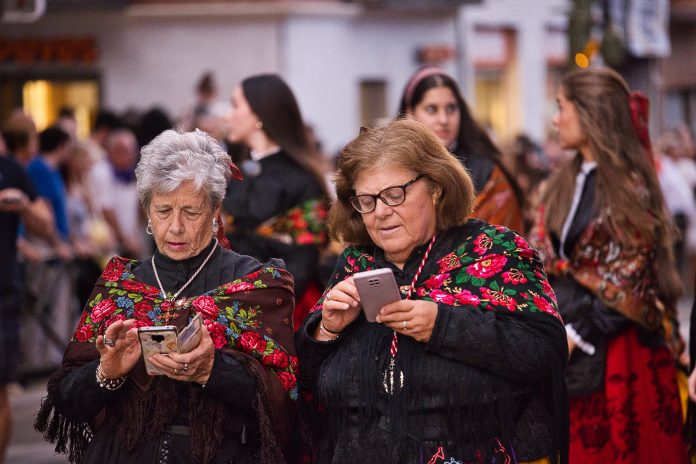 En la procesión de la Virgen de la Antigua hay tiempo incluso para los teléfonos móviles, tan omnipresentes en nuestras vidas.