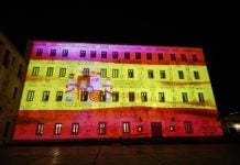 Bandera de España sobre la fachada de las Cortes de Castilla-La Mancha.
