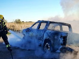 Los bomberos, en plena extinción del coche que ha ardido en Robledillo de Mohernando.