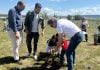 Una de las familias participantes en la plantación, junto a los dos concejales presentes.