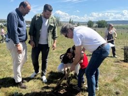 Una de las familias participantes en la plantación, junto a los dos concejales presentes.