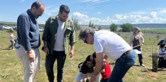 Una de las familias participantes en la plantación, junto a los dos concejales presentes.