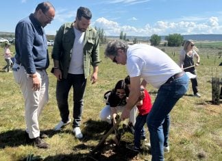 Una de las familias participantes en la plantación, junto a los dos concejales presentes.