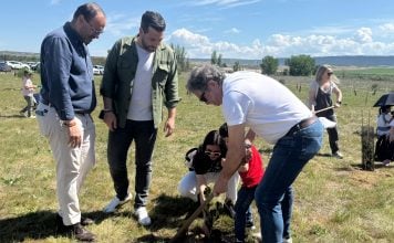 Una de las familias participantes en la plantación, junto a los dos concejales presentes.