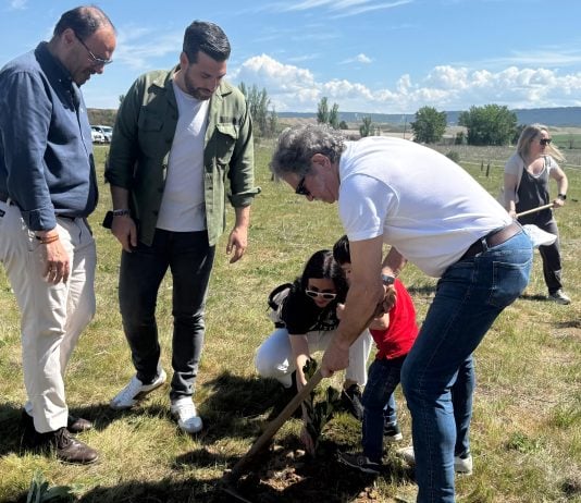 Una de las familias participantes en la plantación, junto a los dos concejales presentes.