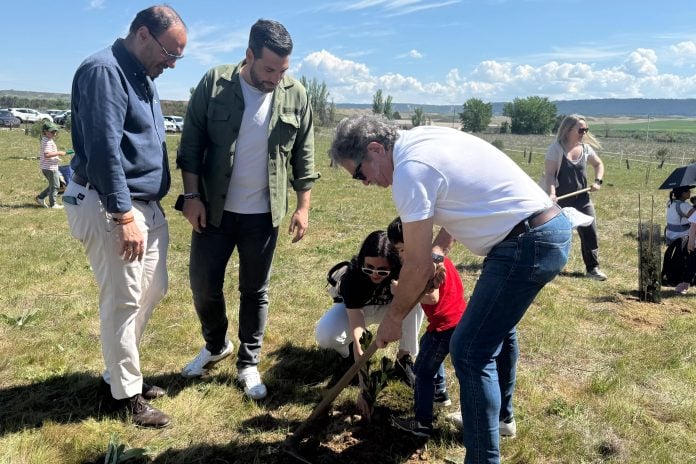 Una de las familias participantes en la plantación, junto a los dos concejales presentes.