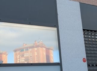 Los locales comerciales podrán adaptarse más fácilmente a pisos en Guadalajara Bloque de viviendas reflejado en un local comercial de Guadalajara. (Foto: La Crónic@)