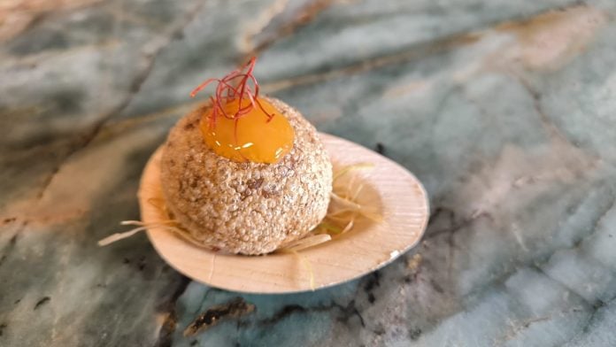 Tapa 'Suflado de trigo relleno de demiglace de cordero, yema curada y chili', de Las Horneras de Cobeta.