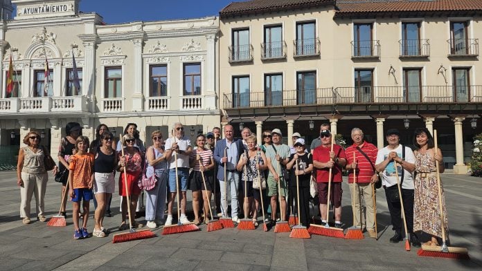 El PSOE y vecinos de algunos barrios de Guadalajara protestan, escoba en mano y durante unos minutos, en la Plaza Mayor, por la falta de limpieza de la ciudad.