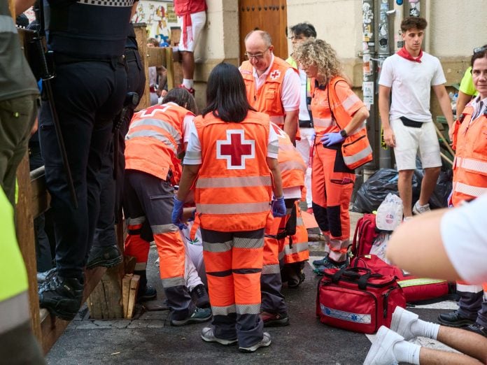 Voluntarios de Cruz Roja atienden a un herido en el sexto encierro de los Sanfermines de 2026. (Foto: Eduardo Sanz / Europa Press)