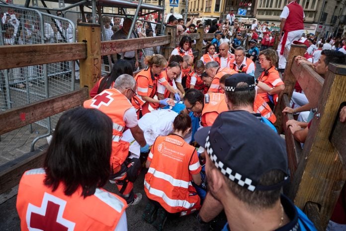 Voluntarios de la Cruz Roja atienden a un herido del último encierro de los Sanfermines de 2026, el 14 de julio. (Foto: Eduardo Sanz / EP)