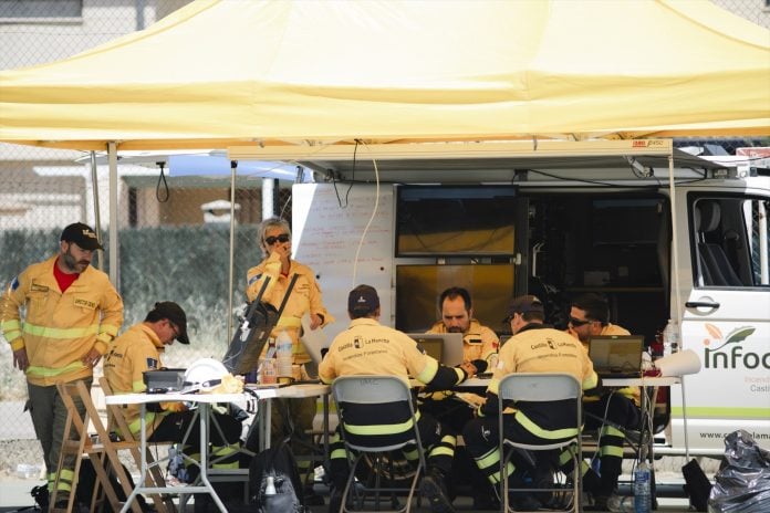 Varias personas trabajan en el Puesto de Mando Avanzado (PMA) durante las labores de extinción del incendio el 18 de julio de 2026, en Tamajón.