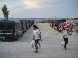 Varios inmigrantes hacen cola para que les den comida en una playa, el 19 de agosto de 2026, en Ceuta. (Foto: EP)