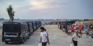 Varios inmigrantes hacen cola para que les den comida en una playa, el 19 de agosto de 2026, en Ceuta. (Foto: EP)