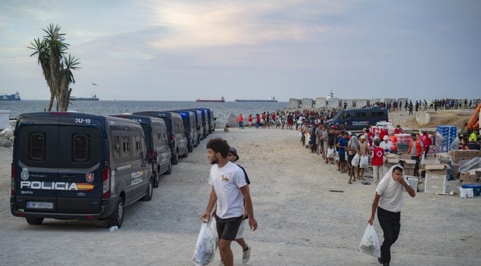 ¿Llegarán menores de Ceuta a Castilla-La Mancha? Varios inmigrantes hacen cola para que les den comida en una playa, el 19 de agosto de 2026, en Ceuta. (Foto: EP)