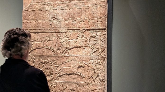Un espectador ante uno de los relieves de la exposición 