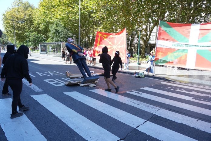 Varios manifestantes encapuchados derriban una estatua del Rey Felipe VI durante la manifestación de la organización juvenil Ernai, el 13 de septiembre de 2026, en San Sebastián, (Foto: EP)